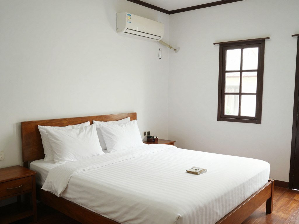Clean budget guesthouse room in Chiang Rai with comfortable bed and basic amenities