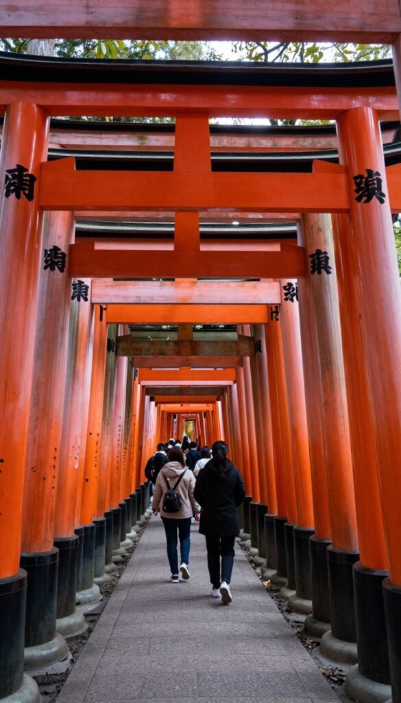 Iconic vermillion torii gate tunnel pathway at Fushimi Inari Shrine leading up mountain
