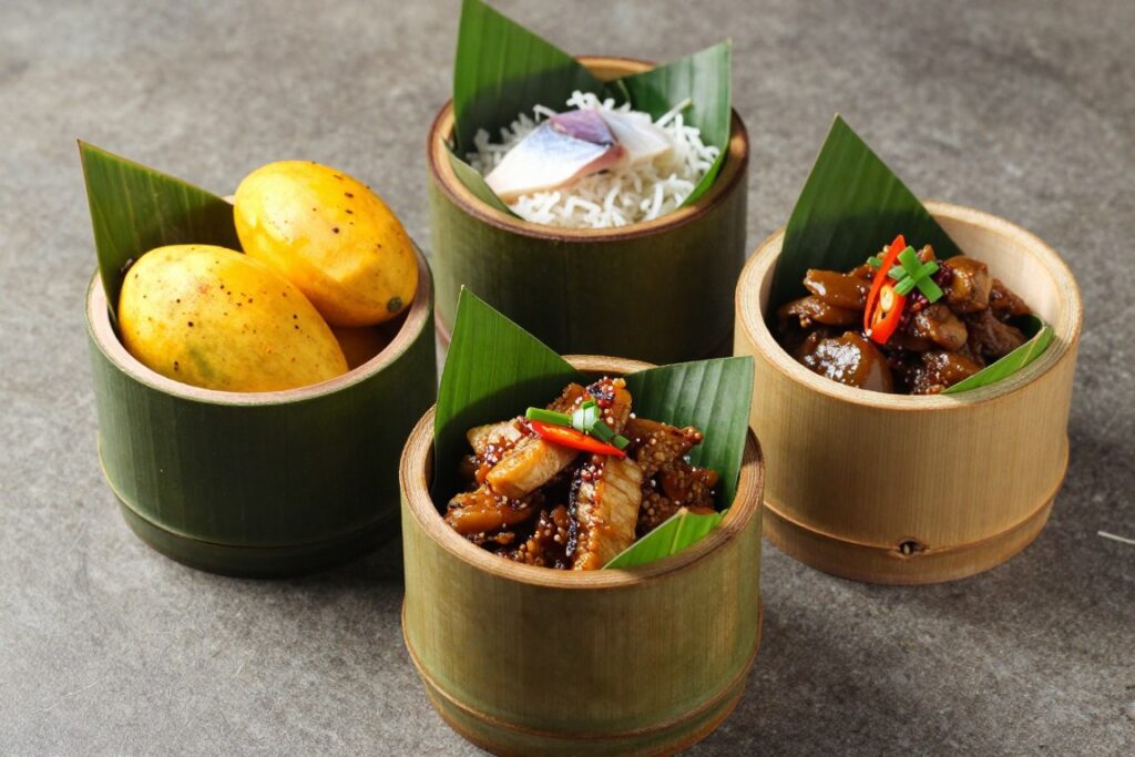 Traditional Sabah dishes served in bamboo containers on banana leaves