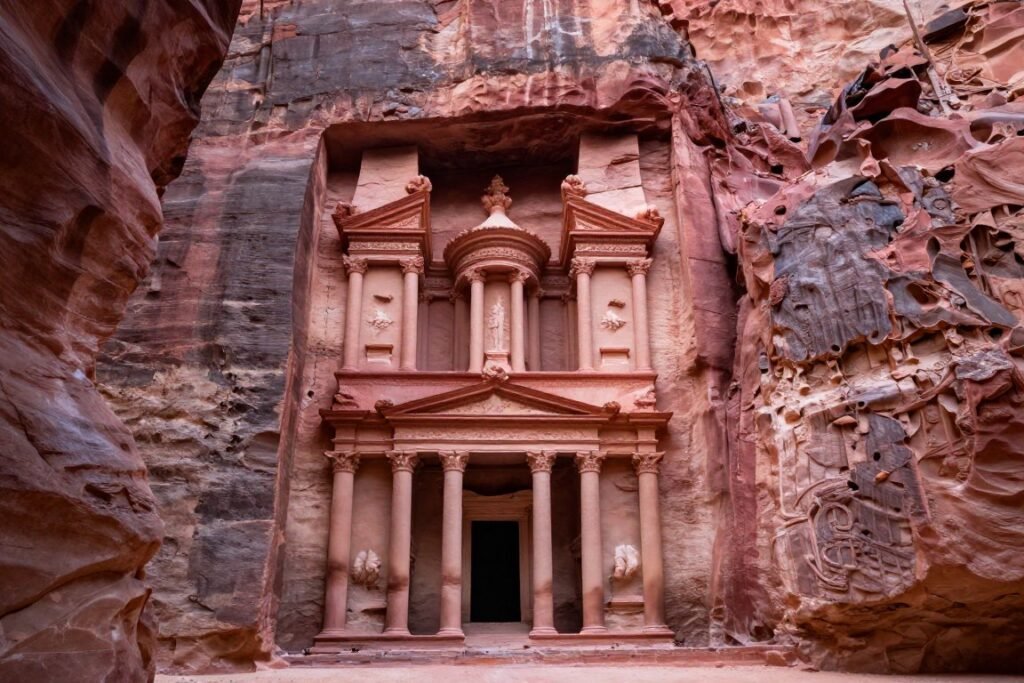 Treasury building at Petra carved into red sandstone cliff face